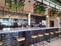 a bar with wooden stools in a restaurant at Acro Residences in Guiguinto