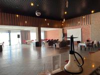 a large room with tables and chairs and a cross on a table at Deluxe Park Qusar Resort & Spa Hotel in Qusar