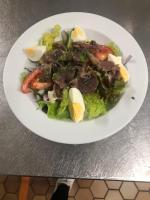 a white plate with a salad on a table at Campanile Clermont-Ferrand Sud Issoire in Issoire