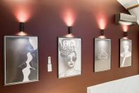 a wall with four pictures on a wall with lights at Luxury Collection &amp; Resort in Cormeilles-en-Parisis