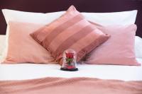 a glass jar with flowers on a bed with pillows at Luxury Collection &amp; Resort in Cormeilles-en-Parisis