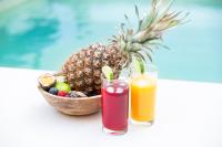 two cocktails and a bowl of fruit next to a pineapple at Luxury Collection &amp; Resort in Cormeilles-en-Parisis