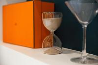 an hourglass sitting on a table next to an orange box at Luxury Collection &amp; Resort in Cormeilles-en-Parisis