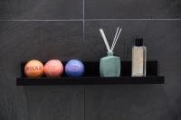 a shelf with three balls and a bottle of soap at Luxury Collection &amp; Resort in Cormeilles-en-Parisis