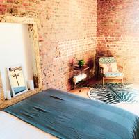 a bedroom with a bed and a brick wall at Little Farm Comfort&amp;PrestigeHouse in Ittre
