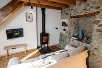 a living room with a couch and a fireplace at Domaine Agricole Cotzé &#47; Casa rural in Enveitg