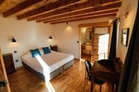 a bedroom with a bed and a desk and a chair at Domaine Agricole Cotzé &#47; Casa rural in Enveitg
