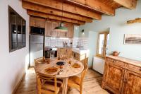 a kitchen with a wooden table and wooden cabinets at Domaine Agricole Cotzé &#47; Casa rural in Enveitg