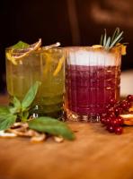 Twee drankjes op een tafeltje naast wat cranberry's. bij Boutique Hotel Marielle in Bad Münstereifel