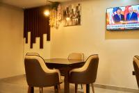 Un comedor con mesa y sillas y un televisor. en Mayfair Hotel Wuse2 Abuja, en Abuja