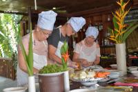 three people in chefs hats preparing food in a kitchen at Hoi An Coco River Resort & Spa in Hoi An