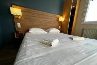 a large white bed with two towels on it at The Originals Access, Hôtel les Iris, Berck-sur-Mer in Berck-sur-Mer
