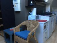 a kitchen with a chair and a counter with a microwave at Studio centre-ville climatisé avec parking gratuit in Clermont-Ferrand