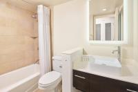 a bathroom with a sink and a toilet and a mirror at Hotel Renew in Honolulu