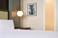 a bedroom with a bed and a picture on the wall at Hotel Renew in Honolulu