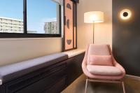 a chair sitting in a room with a window at Hotel Renew in Honolulu