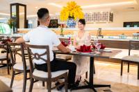 Ha Long Dream Hotel في ها لونغ: رجل وامرأة يجلسان على طاولة في مطعم