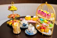 Ha Long Dream Hotel في ها لونغ: طاولة يعلوها قفص مليء بأنواع مختلفة من الحلويات