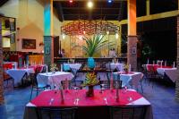 ein Esszimmer mit Tischen mit rot-weißem Tisch in der Unterkunft Crystal Paradise Resort Spa & Winery in Narra