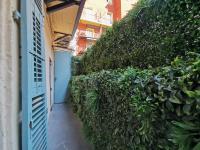an alley with a green hedge next to a building at Le PETIT BALCON by Booking Guys in Nice