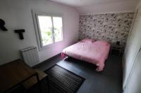 a bedroom with a pink bed and a window at La Cabane aux Acacias~vacances nature et au calme in Mézos