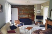 a living room with a couch and a tv at La Cabane aux Acacias~vacances nature et au calme in Mézos