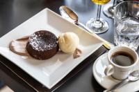 un piatto bianco con un dolce al cioccolato e una tazza di caffè di La Chaumière Mountain Lodge a Chamonix-Mont-Blanc