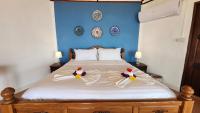 a bedroom with a bed with a blue wall at Banyan Bay Villas in Ko Jum