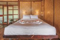 a large white bed with two flowers on it at Banyan Bay Villas in Ko Jum