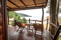 a wooden deck with a table and chairs on the beach at Banyan Bay Villas in Ko Jum