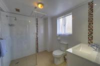 a bathroom with a shower and a toilet and a sink at Acacia Snowy Motel in Jindabyne