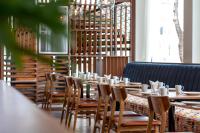 een rij tafels en stoelen in een restaurant bij OUTRIGGER Surin Beach Resort in Surin Beach