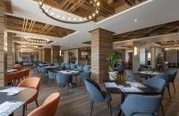 a restaurant with tables and chairs and a chandelier at Ambassadori Goderdzi Hotel in Goderdzi