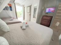 a bedroom with two beds and a tv on the wall at La Rose du Bresil Marie-Galante in Capesterre