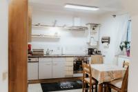 a kitchen with white cabinets and a table and a dining room at Getaway in Bad Ischl in Bad Ischl