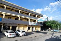 two white cars parked in front of a building at Hotel Internacional Palmerola in Comayagua