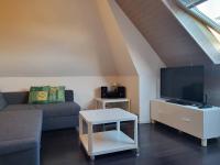 a living room with a couch and a flat screen tv at Appartement Merville-Franceville-Plage, 3 pièces, 6 personnes - FR-1-465-87 in Merville-Franceville-Plage