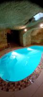 a large blue swimming pool in a cave at Ta Majsi farmhouse with indoor heated pool in San Lawrenz
