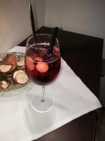 Una bebida en un vaso con dos cubiertos y un plato de comida. en nawu apartments & Restaurant, en Hermagor