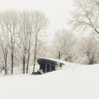 a house covered in snow with trees in the background at Bulle de Bois, écolodge insolite avec spa privatif au milieu des volcans - Bulles d&#39;Herbe in Queyrières