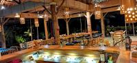 ein Restaurant mit einer Bar, Stühlen und Lichtern in der Unterkunft Sulu Sunset Beach Resort in Nauhang