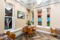 Un restaurante con mesas, sillas y ventanas. en Windermere Manor Hotel, en Windermere