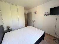 a bedroom with a white bed and a flat screen tv at Appartement Cambo-les-Bains, 2 pièces, 2 personnes - FR-1-495-57 in Cambo-les-Bains