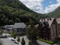 a building in front of a mountain with trees at Appartement Bagnères-de-Luchon, 3 pièces, 6 personnes - FR-1-313-125 in Luchon