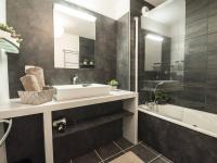 a bathroom with a sink and a tub and a mirror at Appartement Saint-Lary-Soulan, 4 pièces, 10 personnes - FR-1-296-340 in Saint-Lary-Soulan
