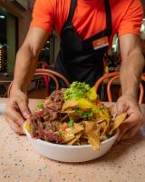 een persoon met een kom eten op een tafel bij Seven Crown La Paz Centro Historico in La Paz