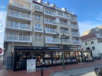 un gran edificio con balcones blancos en una calle en Mainstreet Knokke, en Knokke-Heist