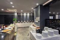 ein Esszimmer mit weißen Tischen und weißen Tellern in der Unterkunft Grandvrio City Danang By Route Inn Group in Đà Nẵng