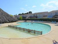 ein großer Pool mit Stühlen und einem Strohschirm in der Unterkunft Maison Vallon-Pont-d&#39;Arc, 3 pièces, 6 personnes - FR-1-382-121 in Vallon-Pont-dʼArc