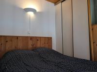 1 dormitorio con 1 cama con luz en la pared en Studio Villard-de-Lans, 1 pièce, 4 personnes - FR-1-548-28, en Villard-de-Lans